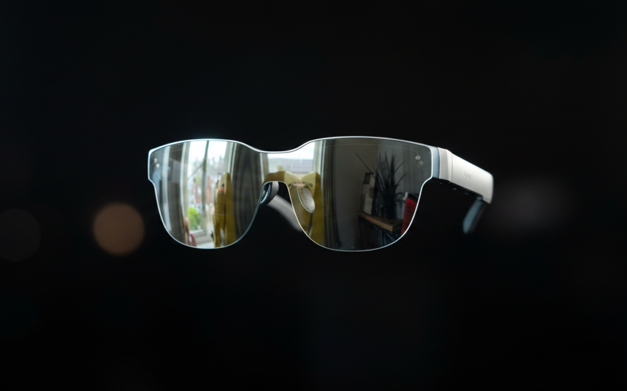RayNeo Air 3s AR glasses floating on a dark cinematic surface showing a virtual movie screen