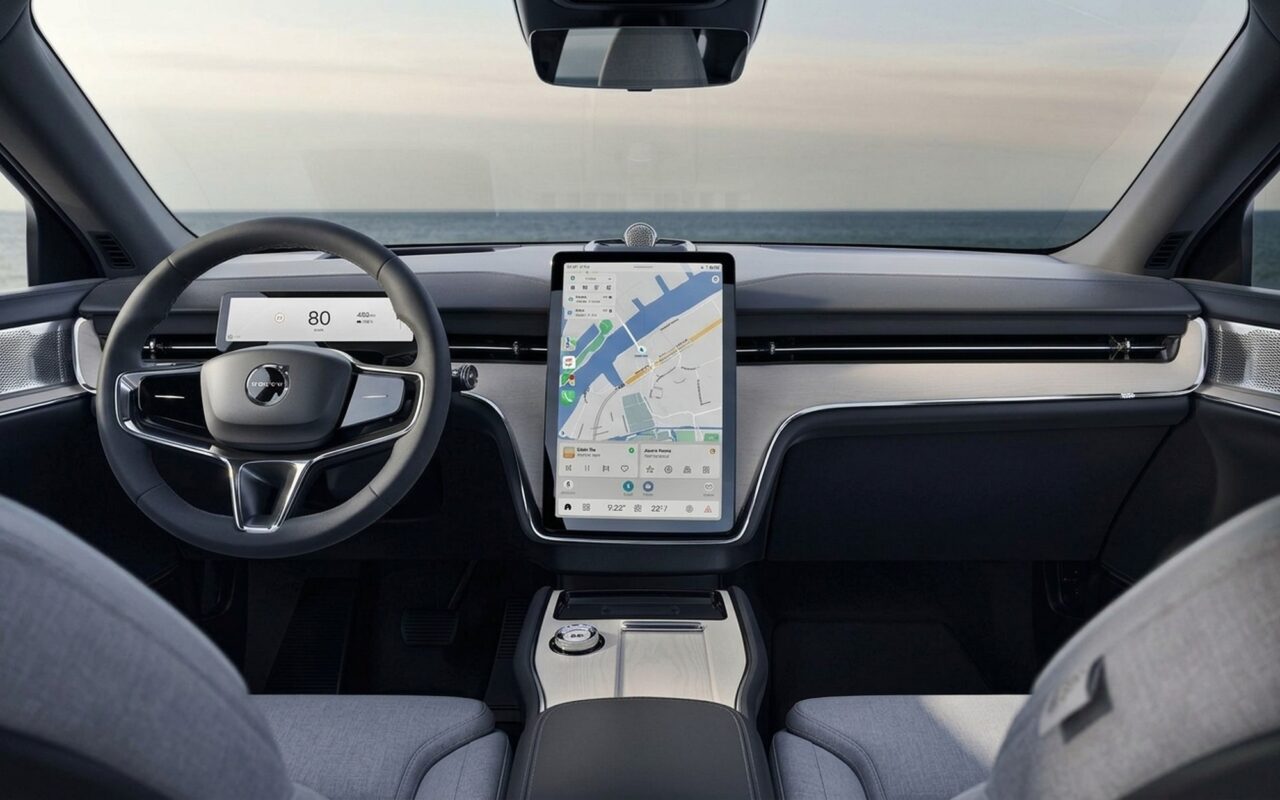 Premium EV car interior with large vertical touchscreen showing Android Auto Google Maps 3D navigation, clean minimalist dashboard with soft daylight through windshield