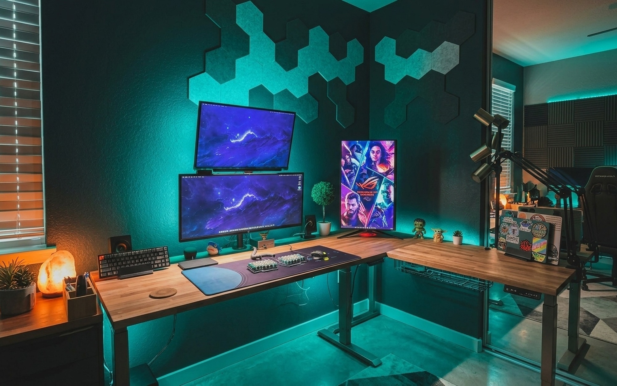 L-shaped electric height adjustable gaming desk with RGB mousepad and dual monitors in a corner home office gaming setup