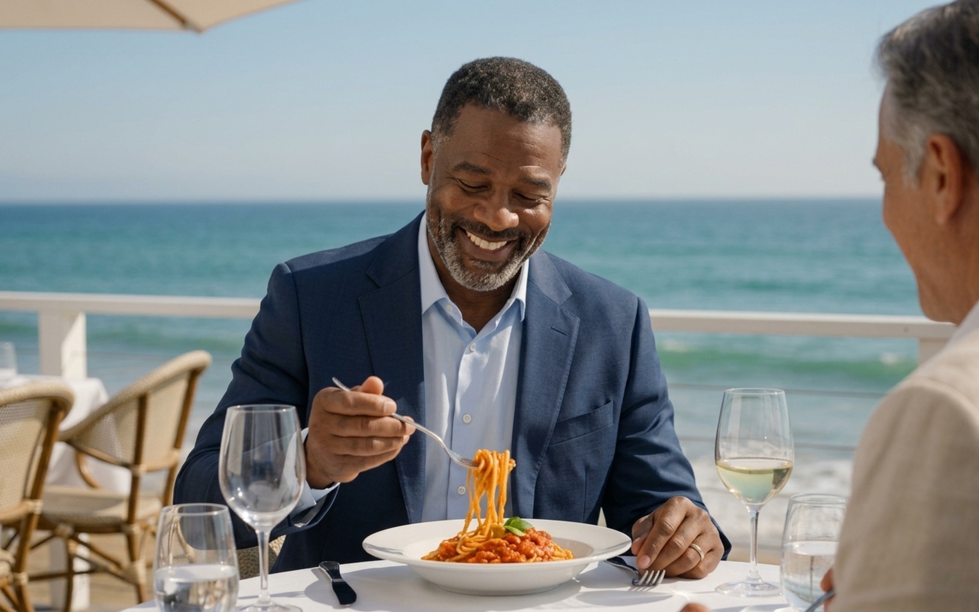 Photorealistic AI-generated video still produced by Google Gemini Omni video generation model showing two men dining outdoors at beachside restaurant