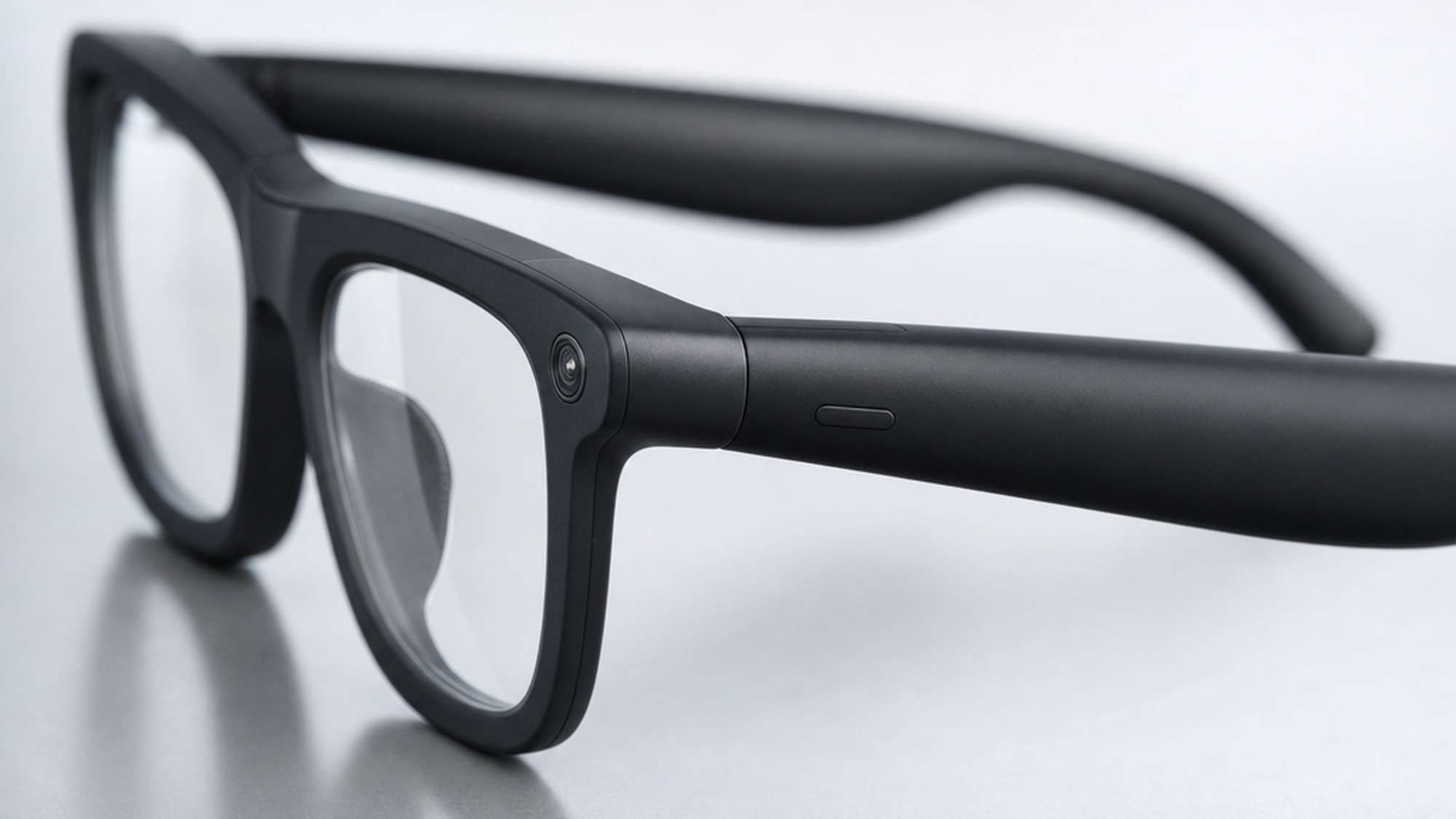 Close up of the RayNeo V4 temple showing the OG09B camera lens and shutter button in matte black finish