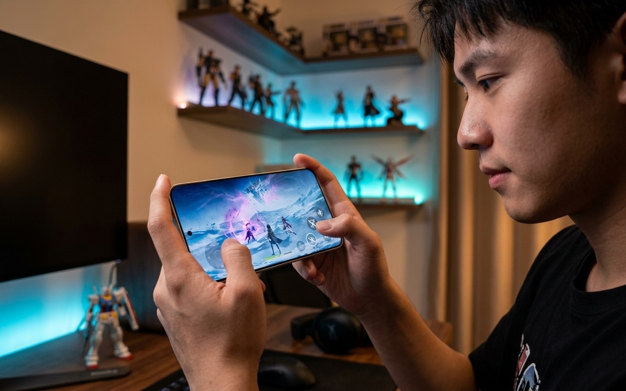 Young man at gaming desk holding REDMI K90 Max in landscape mode with vivid RPG game displayed on screen