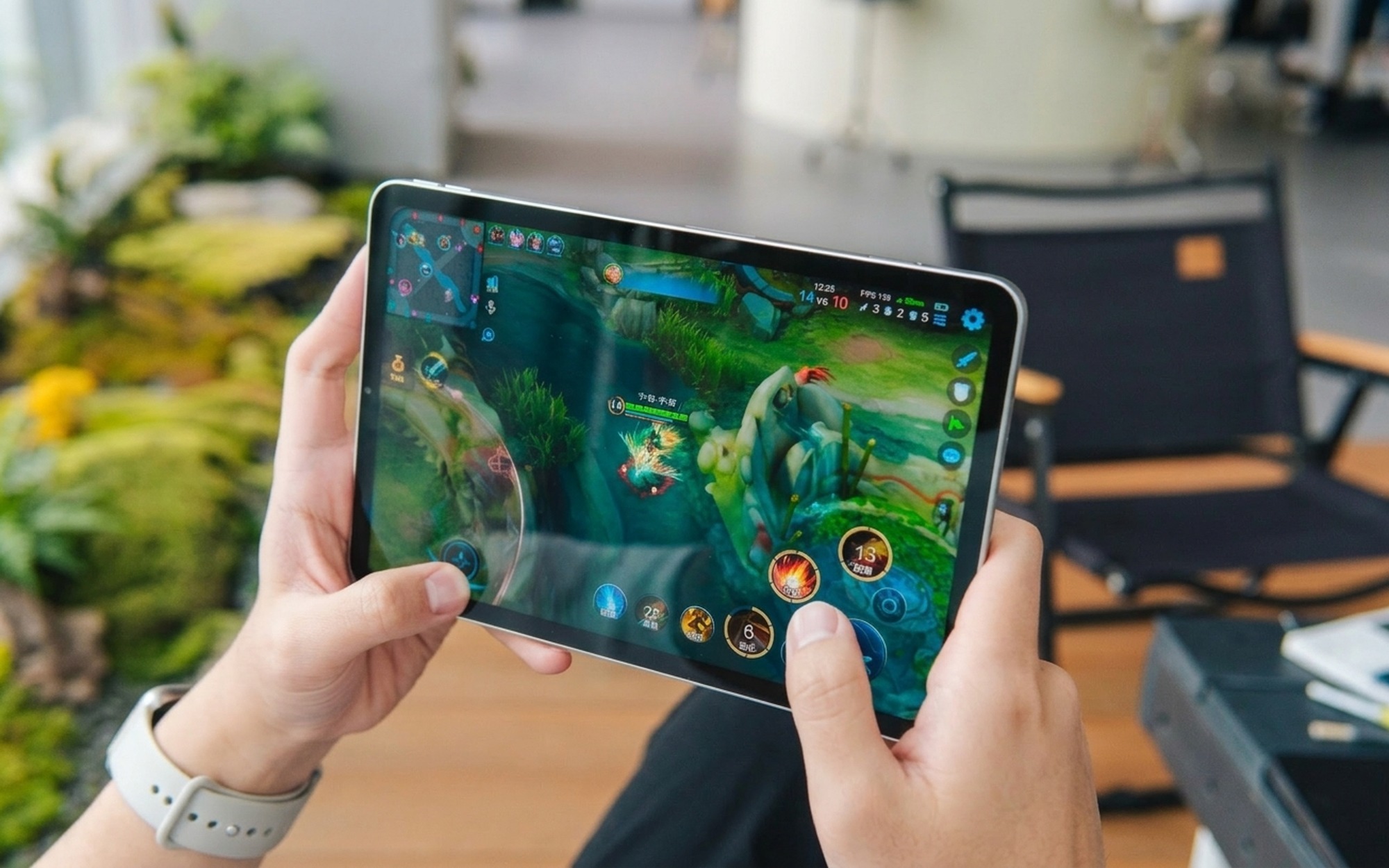 Redmi KPad 2 held in landscape gaming position with USB-C cable plugged into the long edge demonstrating bypass charging during gameplay