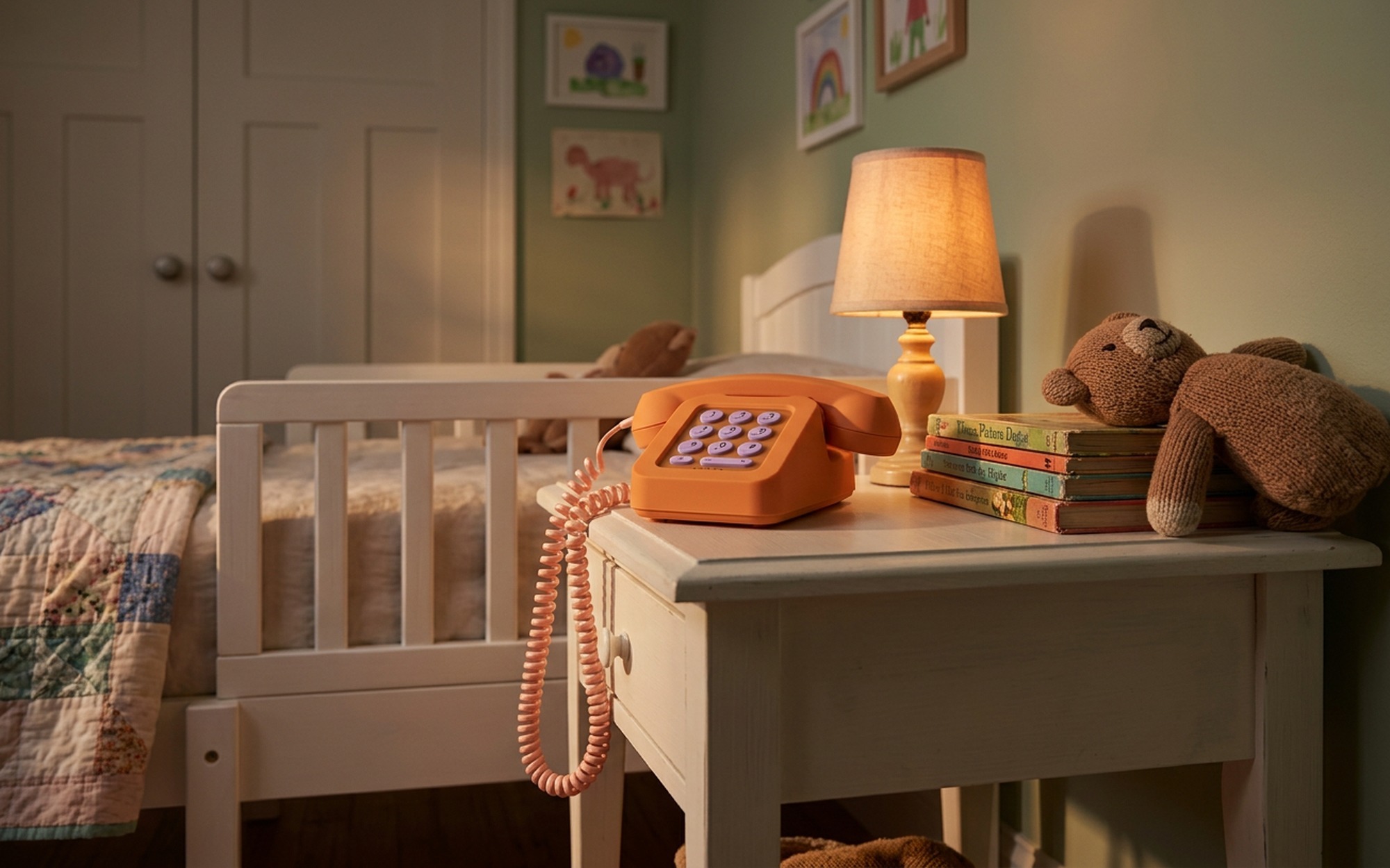 Tin Can WiFi landline phone for kids on a child's bedroom nightstand beside a stack of books and a small bedside lamp