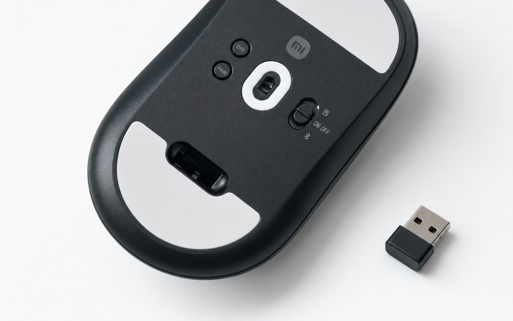 Xiaomi Gaming Mouse 2 bottom panel showing USB dongle stored in recessed compartment with PAW3955XM sensor visible