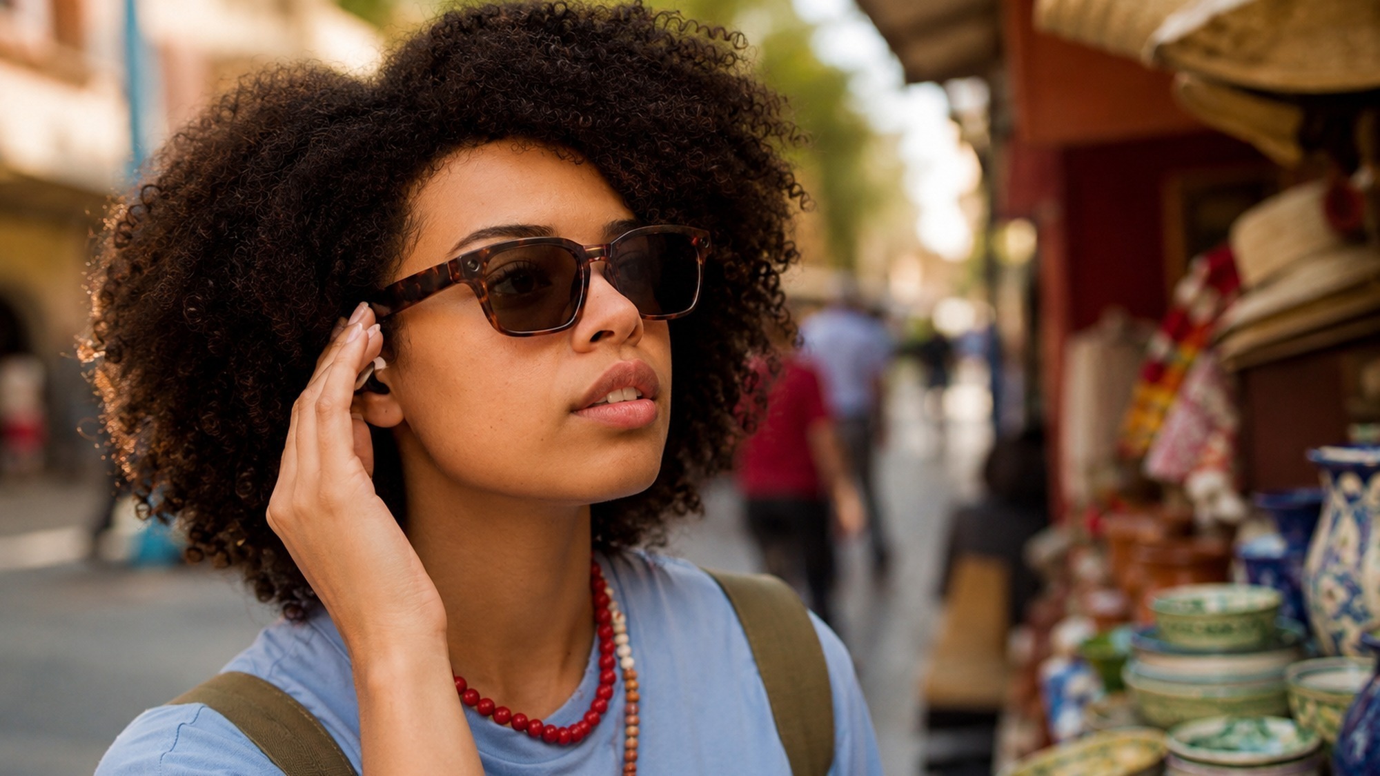 Traveler wearing Meta AI glasses using real time translation while talking to a shop owner abroad without a phone.