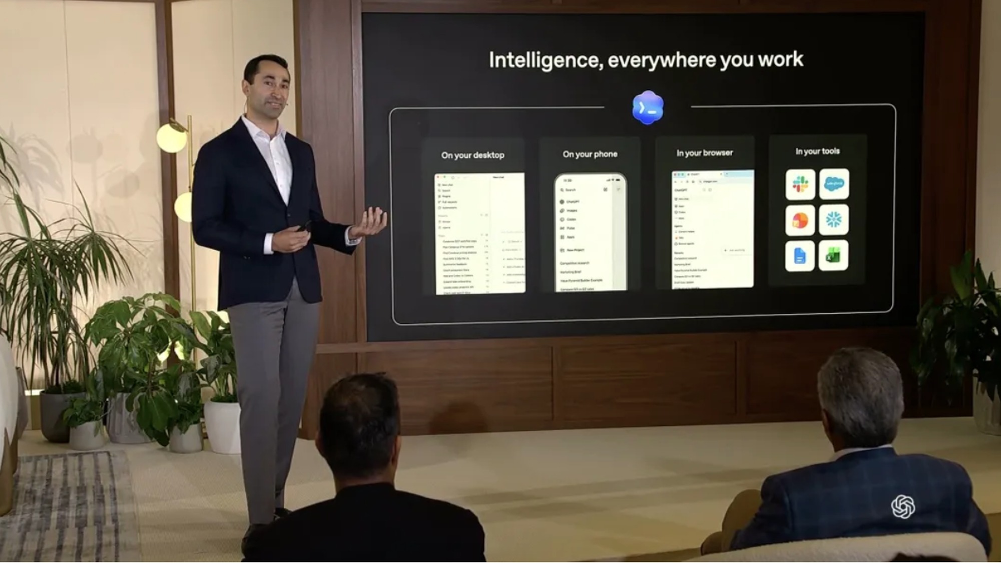 OpenAI presenter on stage introducing Codex with Intelligence everywhere you work slide showing ChatGPT on desktop phone browser and connected business app icons