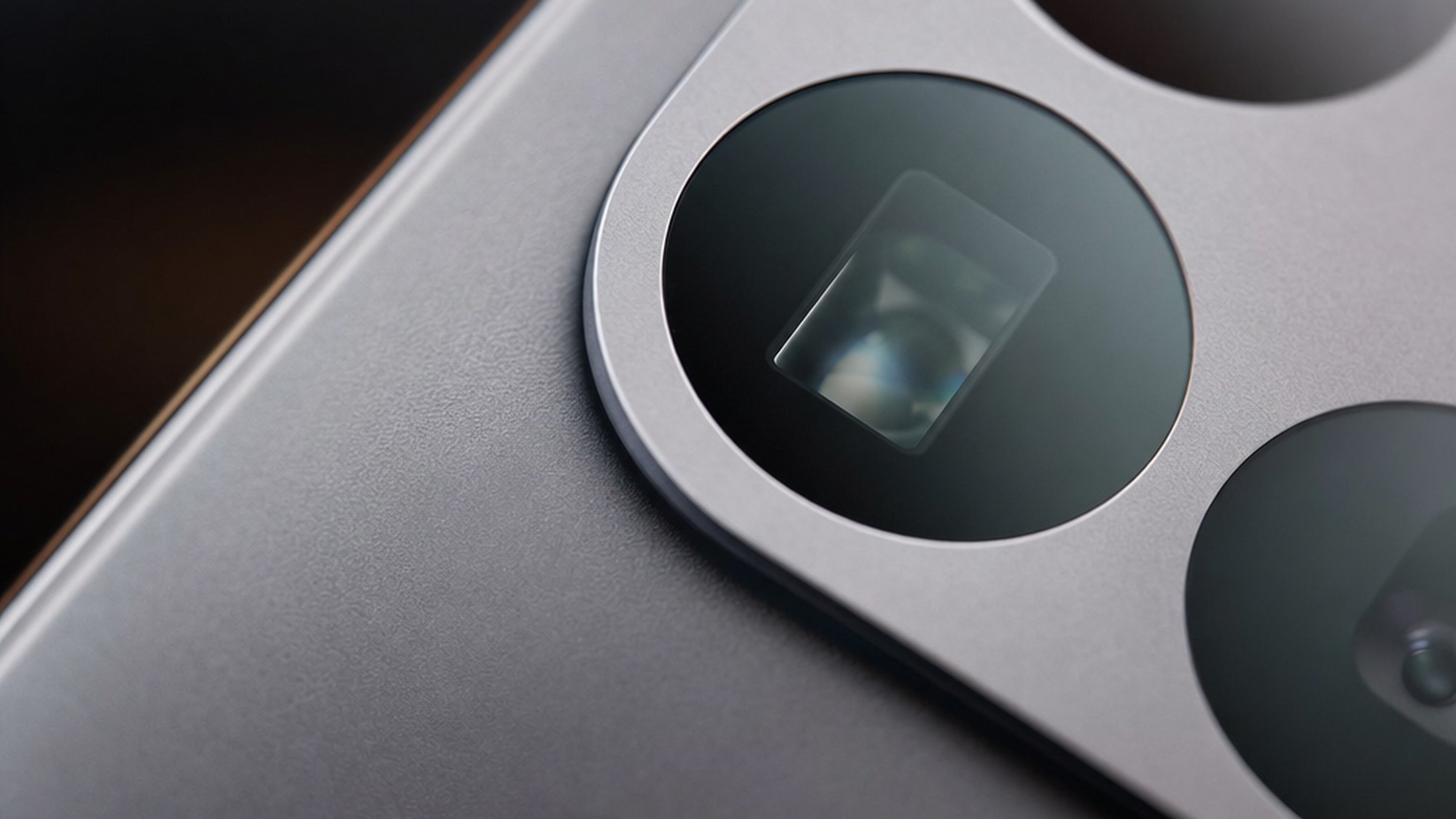 Macro detail shot of the Xiaomi 17T Pro periscope telephoto lens glass and metal ring with the other lenses softly out of focus.